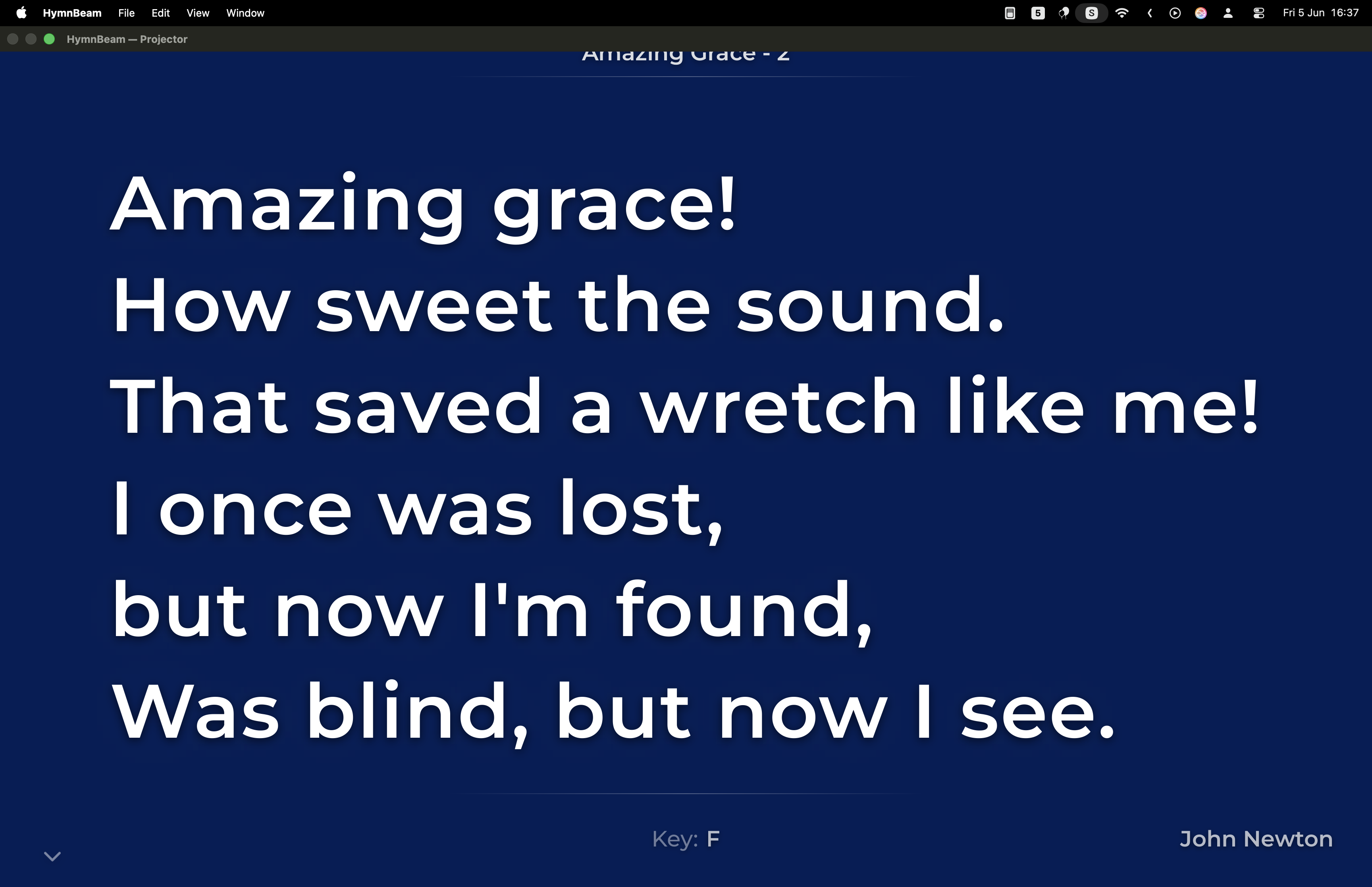 HymnBeam projector output showing large white lyrics on a deep navy background